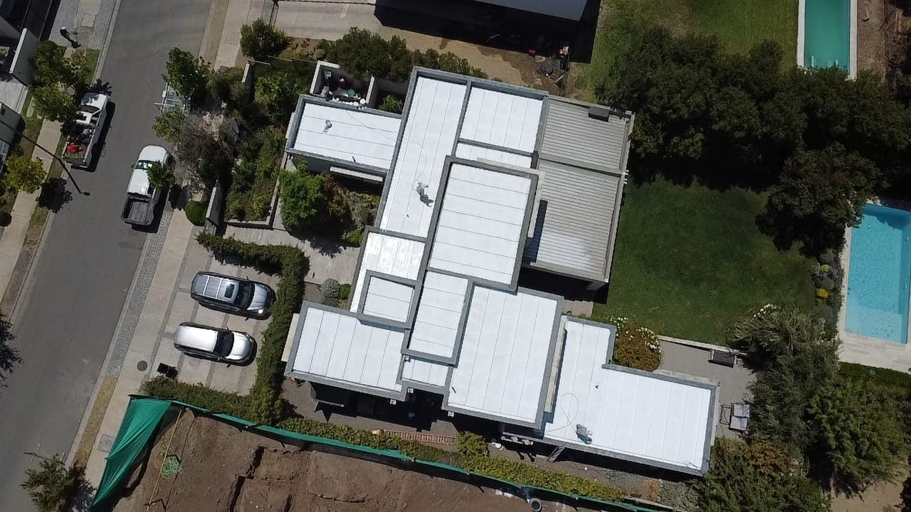 Vista aérea de casa grande con techo completo aplicado en blanco con aislante térmico Köner